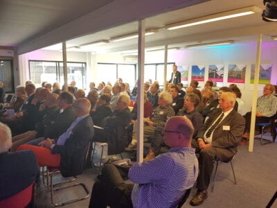 Stakholderbijeenkomst bij het kantoor van DNA. Je ziet een groep met mensen in een ruimte op stoelen zitten.