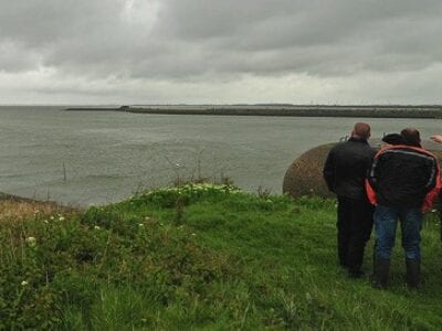 De foto is gemaakt tijdens een BB expertmeeting bij Kornwerderzand. Op de foto zie je vijf mannen uitkijkend op het water.
