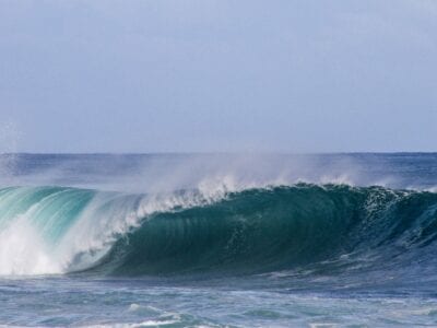 Wij zien een stukslaande golf op het blauwe water.