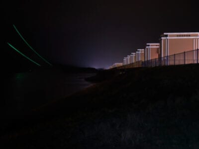 Gates of Lights in het donker met lichtstrips. Door reflectie van de koplampen lichten de strips links en rechts op.
