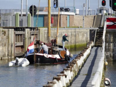 Er ligt een boot in de sluis bij Kornwerderzand. Dit schip vaart in laagwater en wacht tot de brug opengaat.