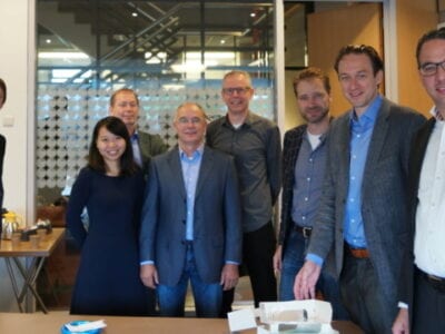 Bijeenkomst bij TU Delft over het onderzoek naar trillingen en golfklappen. Er staat een groep mensen op een rij.