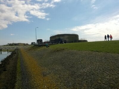 Museumweekend bij de Kazematten. We zien een drietal mensen over de dijk bij de Kazematten lopen.