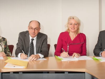 Groepsfoto van de bestuurlijke stuurgroep van de Afsluitdijk. Twee dames en twee heren zitten naast elkaar.