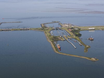 Van boven kijken we uit op de weg en sluizen van de Afsluitdijk.