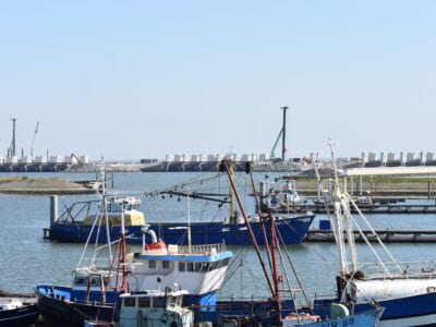 We zien de haven van Den Oever. Voor in het water liggen de bootjes.