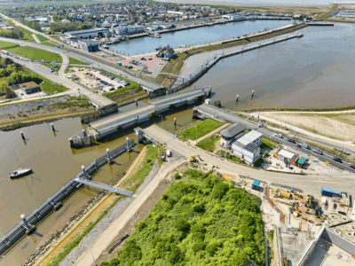 Luchtfoto op land met een aantal wegen. Water en draaibruggen die open staan.