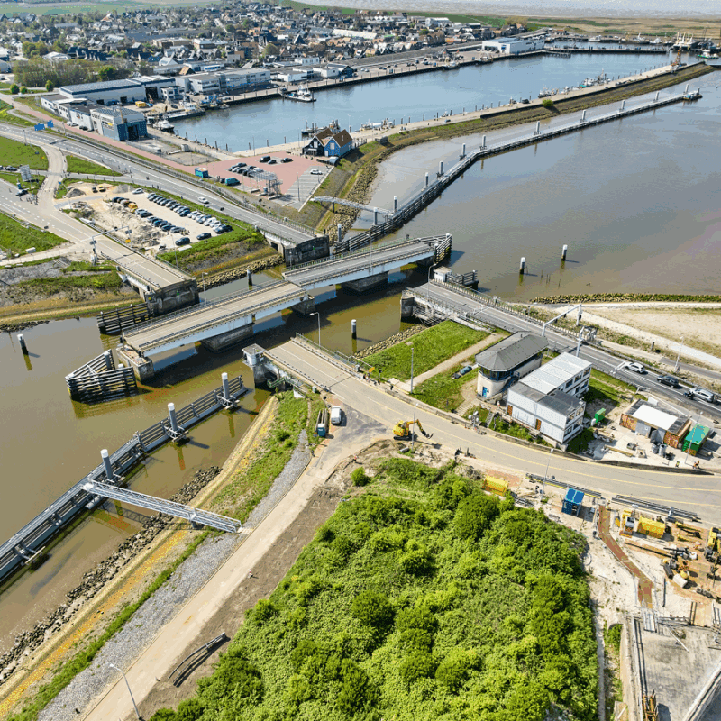 Luchtfoto op land met een aantal wegen. Water en draaibruggen die open staan.