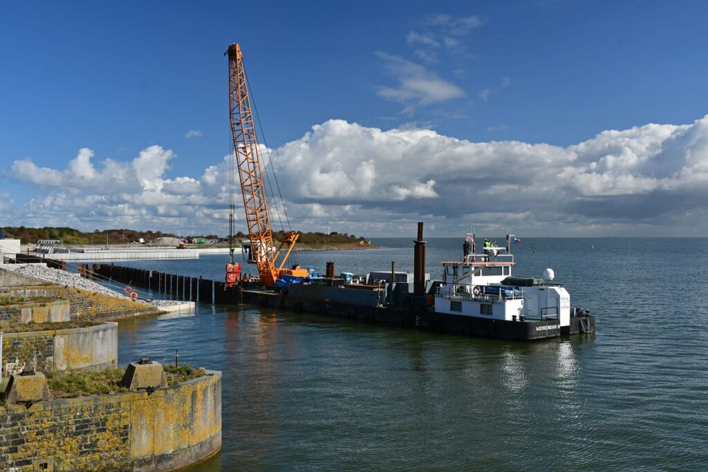 kraanschip in het water met links de kade