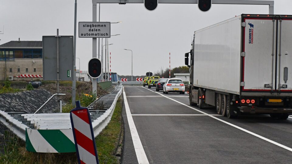We zien dat het wegverkeer weg rijdt achter gele wagens aan van Rijkswaterstaat.