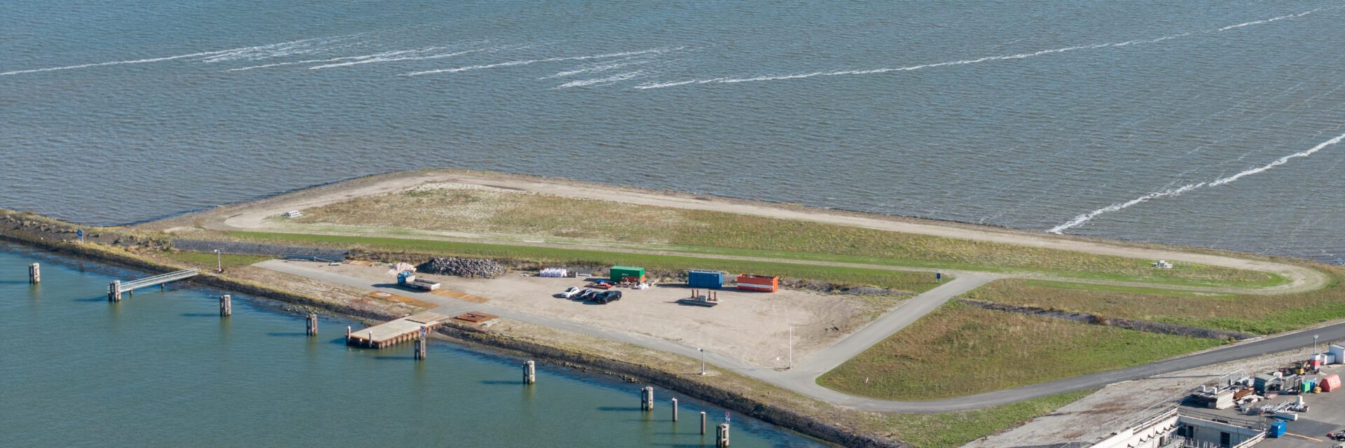 Een groen vlakte bij het water.
