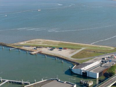 Een groen vlakte bij het water.