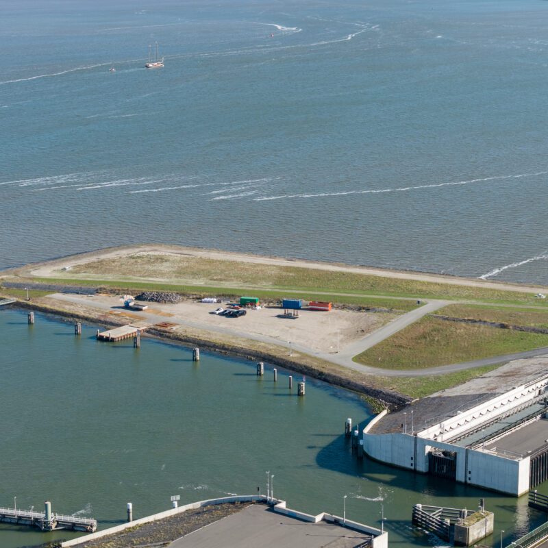 Een groen vlakte bij het water.